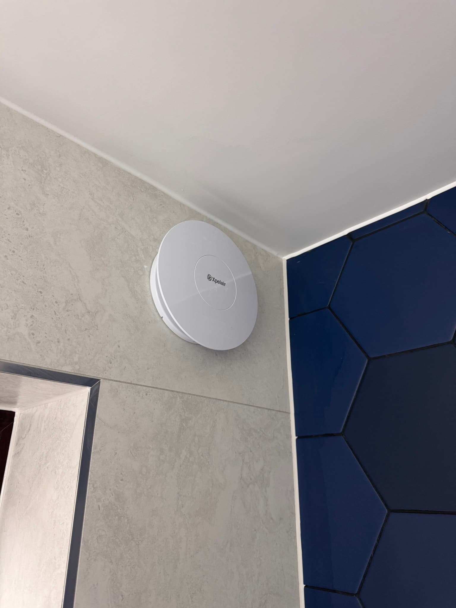 Wet room floor with navy hexagonal mosaic tiles
