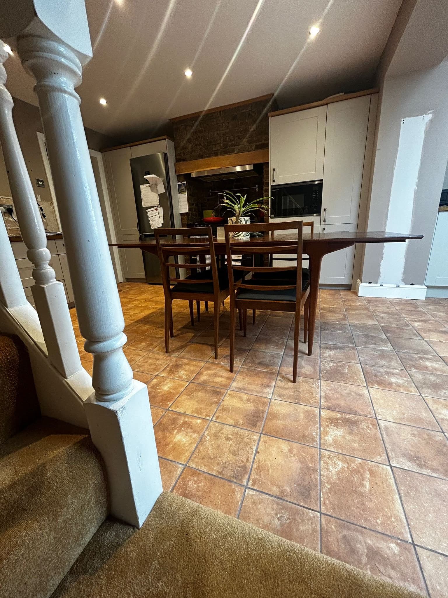 Kitchen diner with travertine floor viewed from staircase