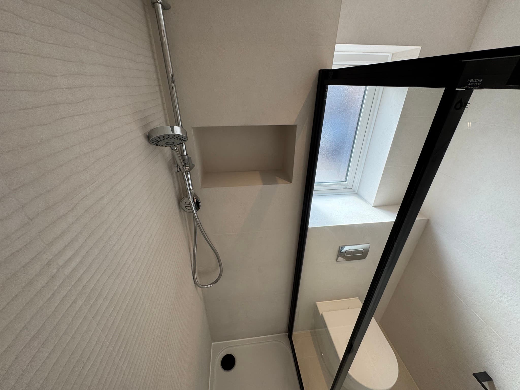 Minimalist shower with cream ribbed tiles and recessed niche