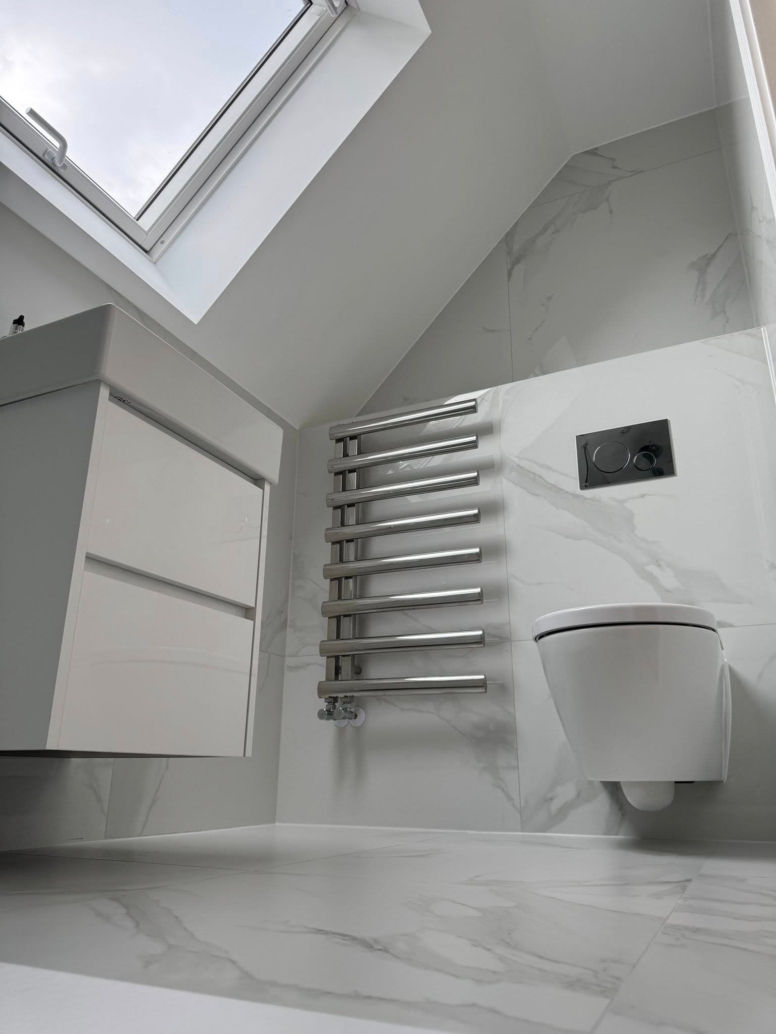 Loft bathroom with Calacatta marble-effect tiles and chrome towel rail